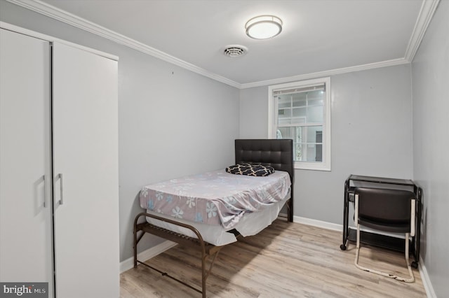 bedroom featuring ornamental molding and light wood-type flooring