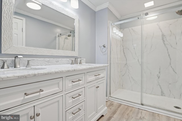 bathroom with vanity, crown molding, wood-type flooring, and a shower with door