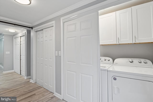 laundry area featuring cabinets, light wood-type flooring, washer and clothes dryer, and ornamental molding