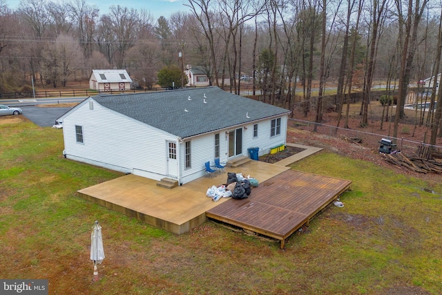 back of property featuring a lawn and a deck