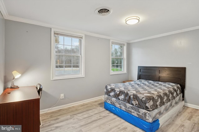 bedroom with light hardwood / wood-style floors, multiple windows, and crown molding