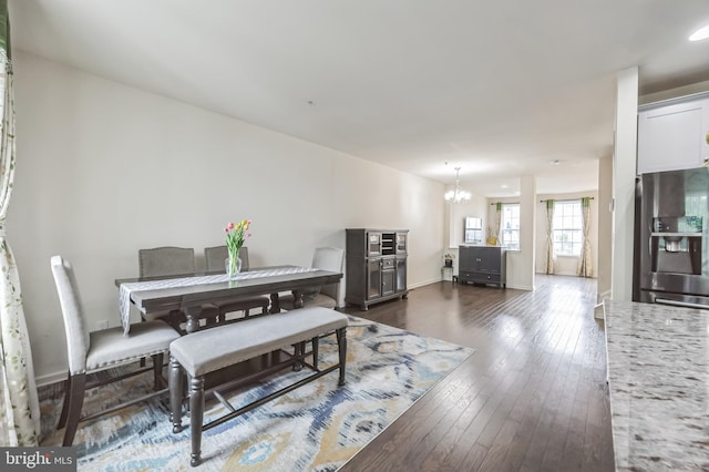 dining space with an inviting chandelier and dark wood-type flooring