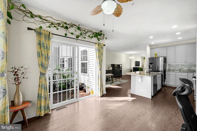 kitchen featuring light stone counters, white cabinets, dark wood-type flooring, and a center island