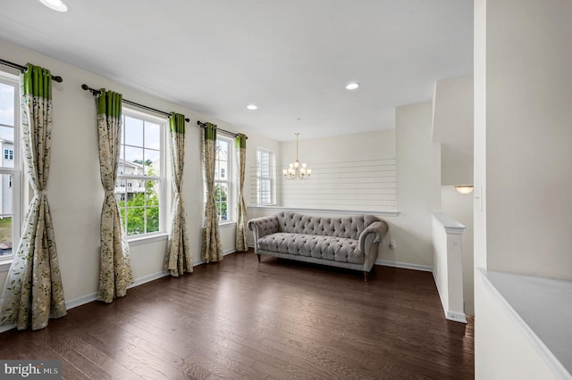 living area with an inviting chandelier and dark hardwood / wood-style floors