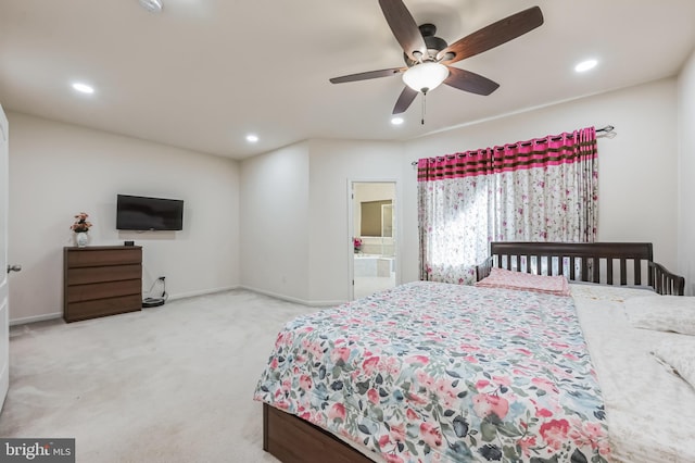 carpeted bedroom featuring ensuite bath and ceiling fan