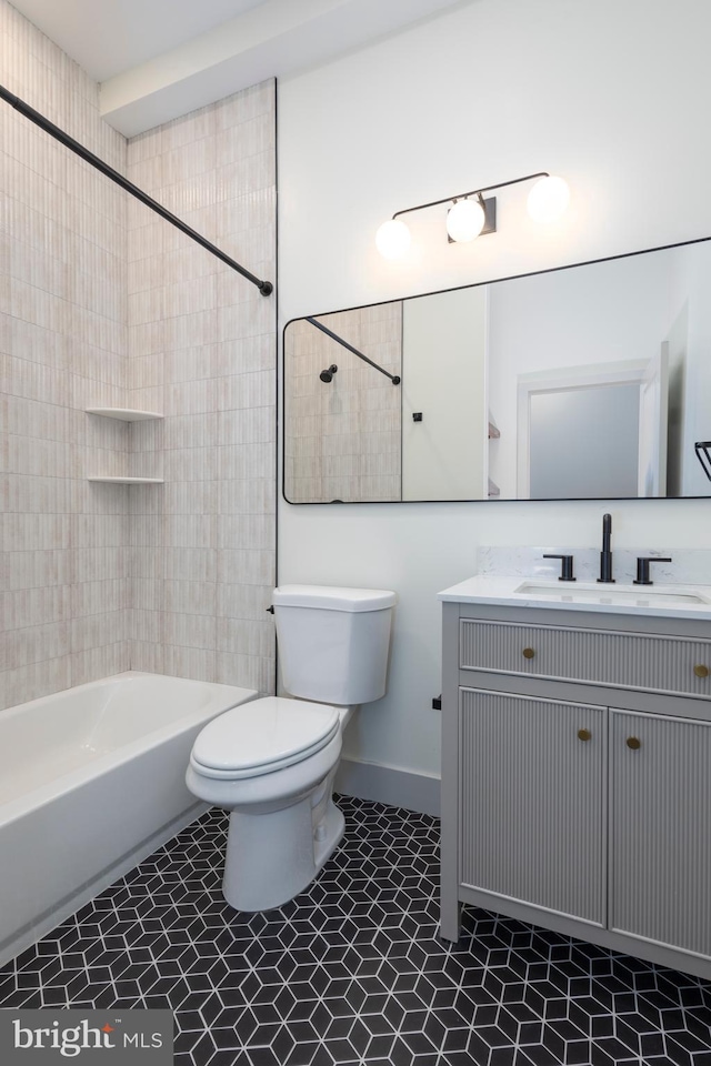 full bathroom featuring tiled shower / bath, vanity, toilet, and tile patterned flooring