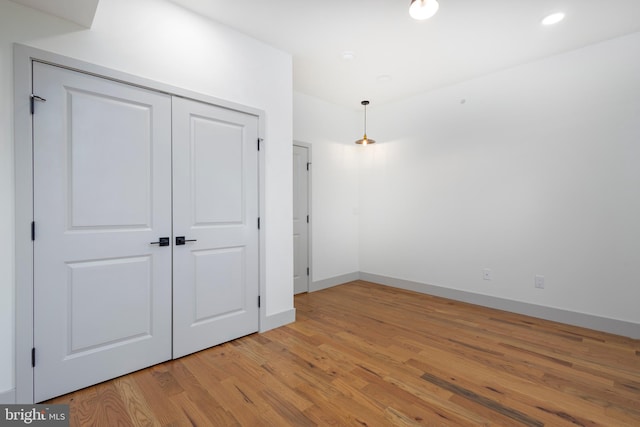 unfurnished bedroom featuring light hardwood / wood-style flooring and a closet