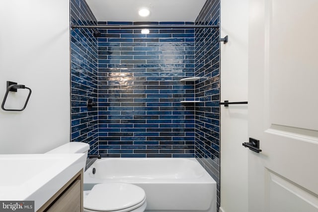 full bathroom featuring vanity, tiled shower / bath combo, and toilet