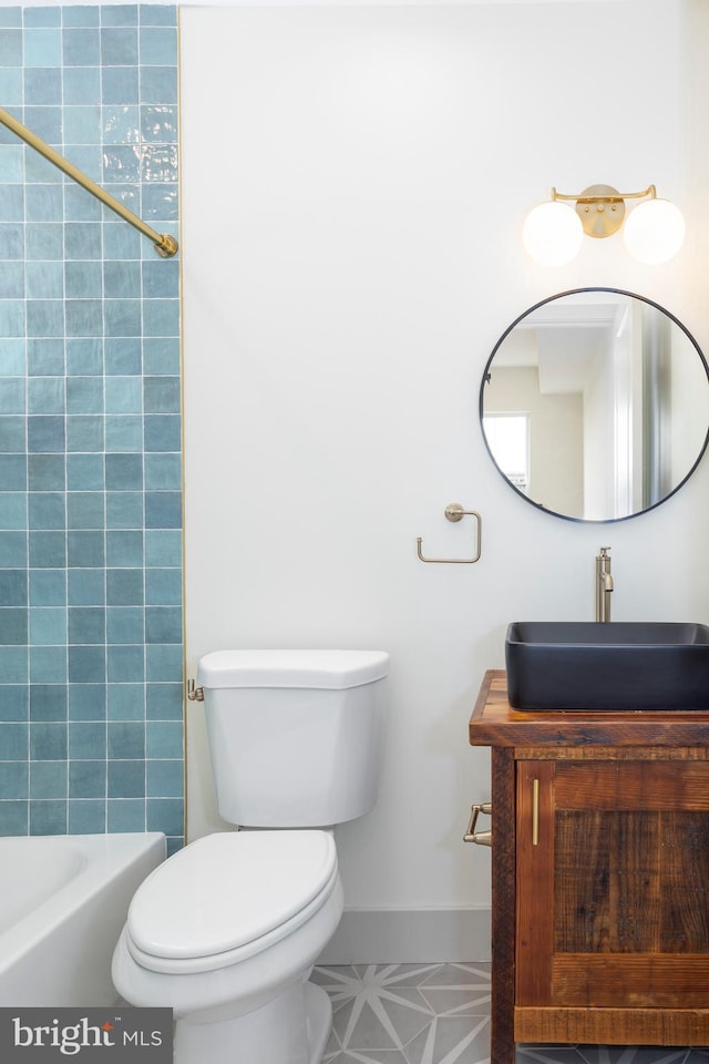 full bathroom featuring toilet, tiled shower / bath combo, vanity, and tile patterned floors