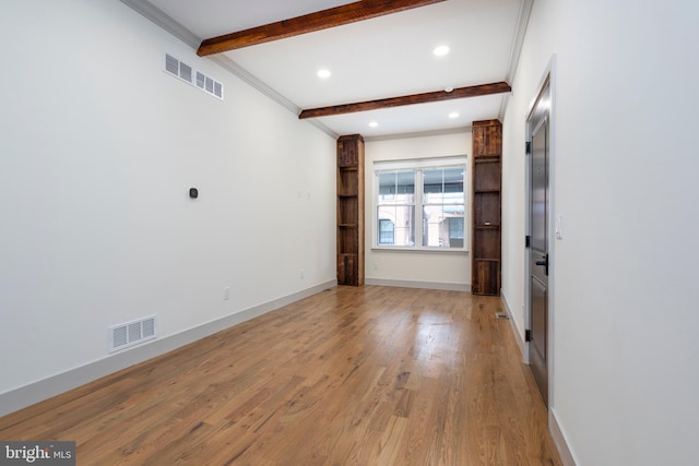 spare room with light hardwood / wood-style flooring, beamed ceiling, and crown molding