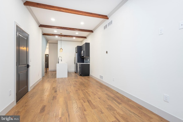 unfurnished room with crown molding, beamed ceiling, sink, and light wood-type flooring