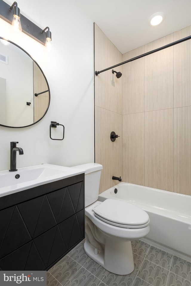 full bathroom featuring tiled shower / bath, vanity, and toilet