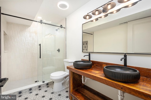 bathroom featuring vanity, toilet, and a shower with shower door