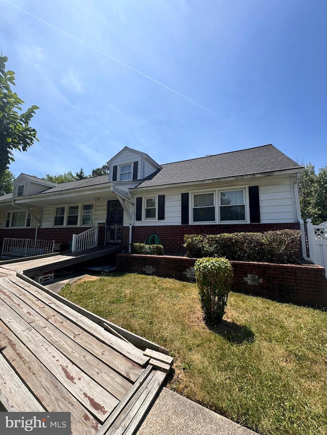 view of front of property featuring a deck and a front lawn