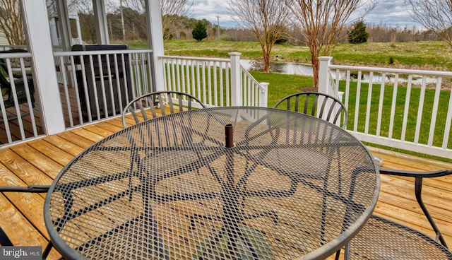 wooden deck with a yard and a water view