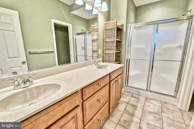 bathroom with tile patterned flooring, a shower with shower door, and vanity