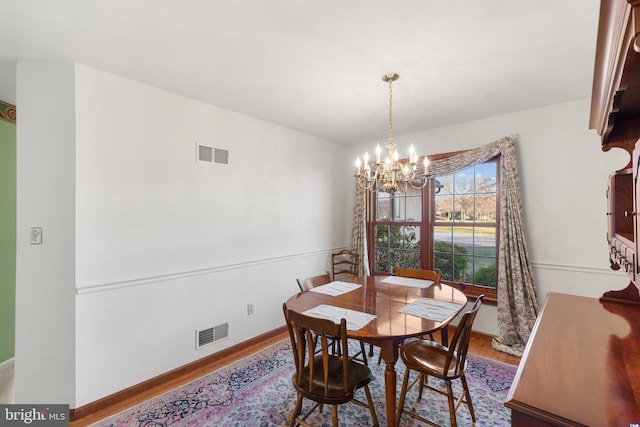 dining room with an inviting chandelier and light hardwood / wood-style flooring