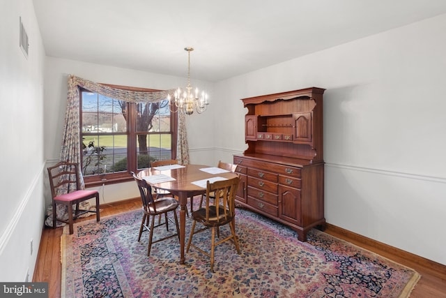 dining space with a notable chandelier and wood-type flooring