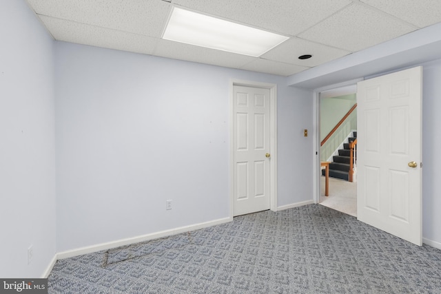 carpeted empty room featuring a paneled ceiling