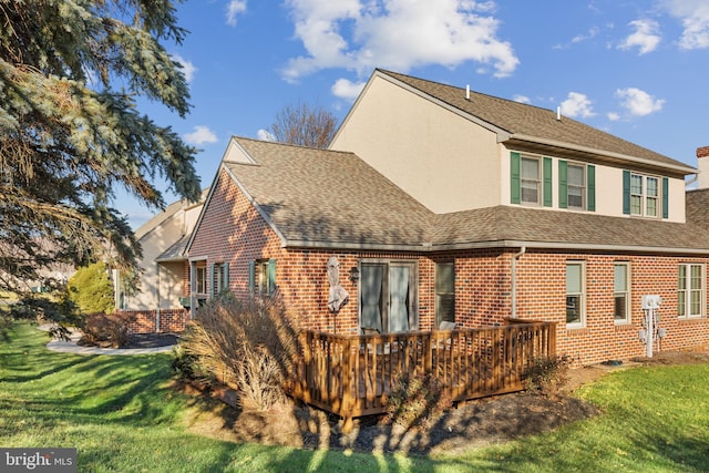 rear view of house featuring a yard and a wooden deck