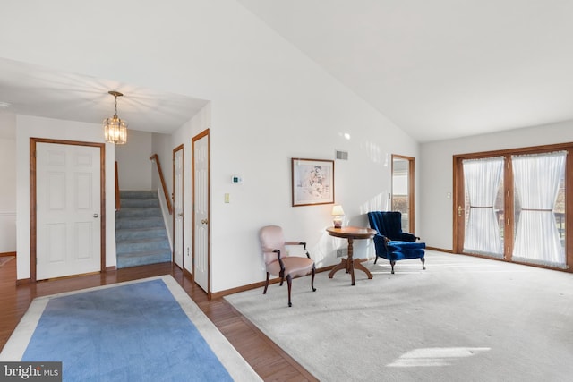 interior space featuring wood-type flooring, high vaulted ceiling, and a notable chandelier