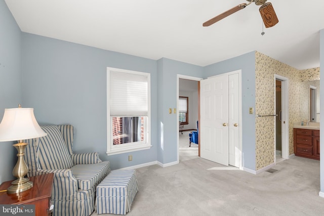 sitting room with ceiling fan and light colored carpet