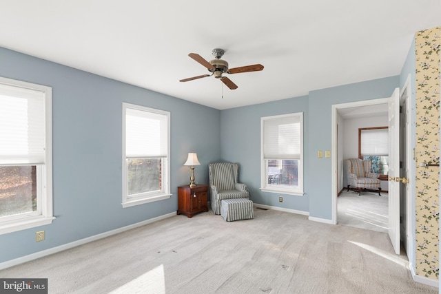 living area featuring light carpet, plenty of natural light, and ceiling fan