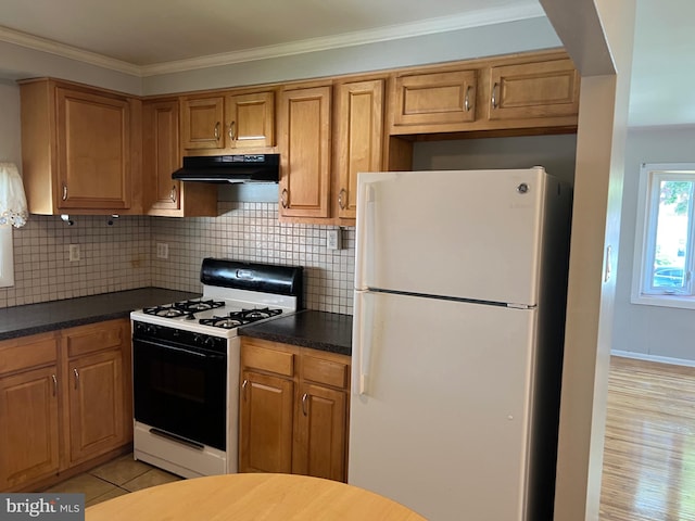 kitchen with backsplash, crown molding, light tile patterned floors, and white appliances