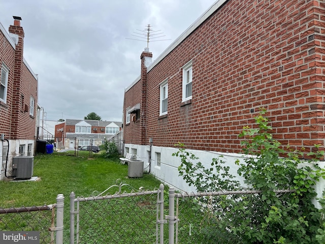 view of side of property with central AC and a yard