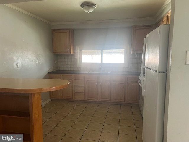 kitchen with crown molding, sink, light tile patterned floors, white refrigerator, and range