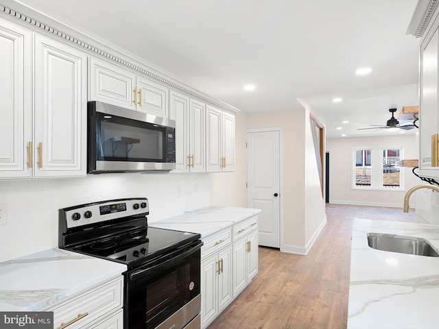 kitchen featuring sink, white cabinetry, stainless steel appliances, and light hardwood / wood-style floors