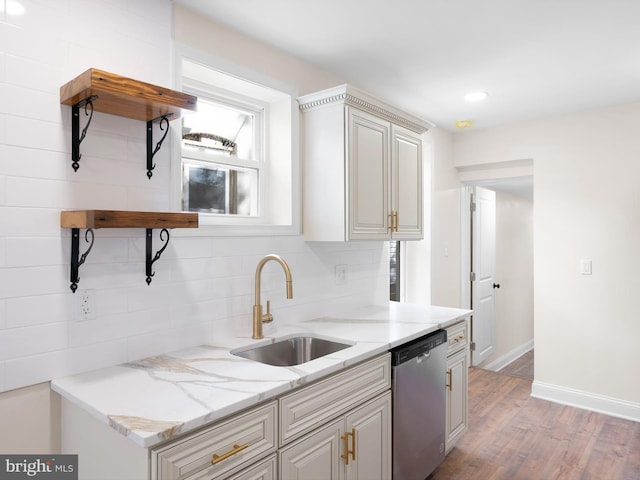 kitchen featuring decorative backsplash, dishwasher, light hardwood / wood-style flooring, sink, and light stone counters