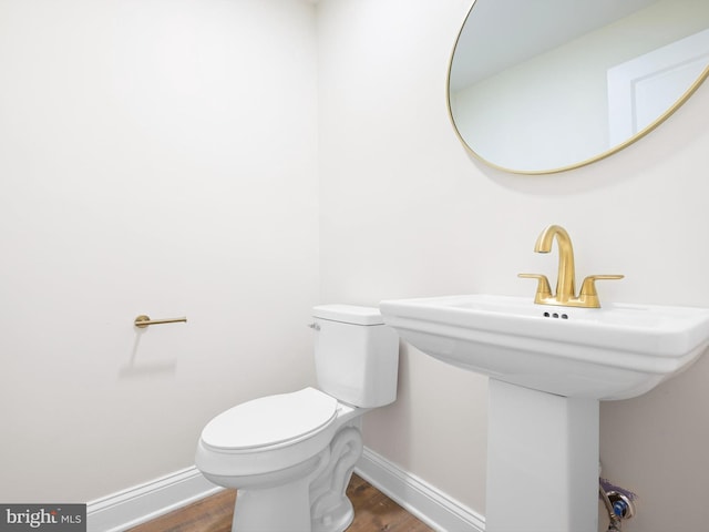 bathroom with toilet, sink, and hardwood / wood-style floors