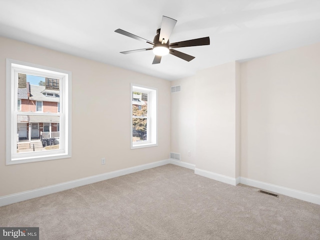 empty room with light colored carpet and ceiling fan