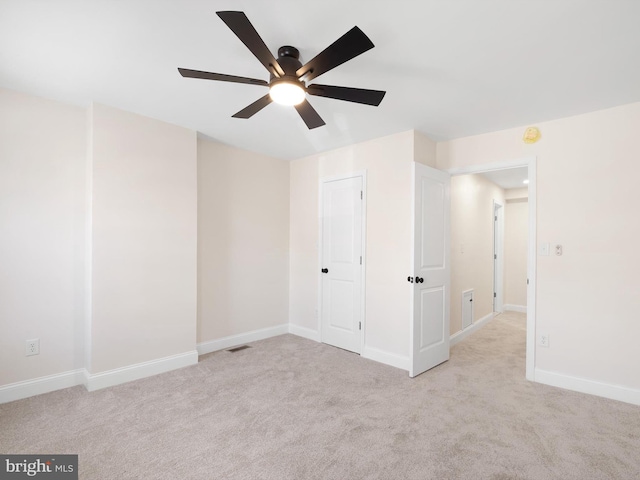 unfurnished room featuring light carpet and ceiling fan