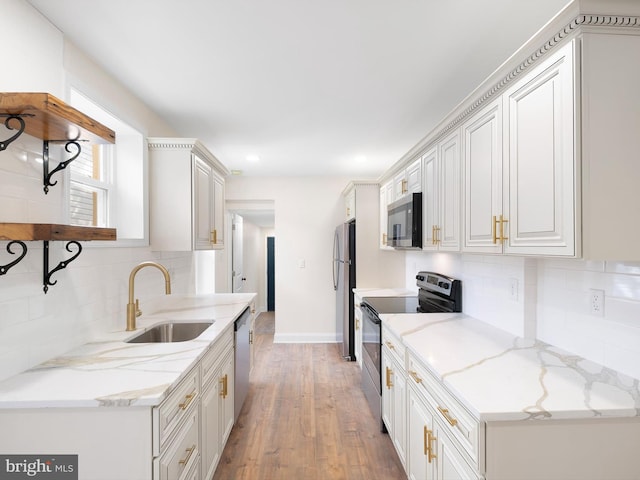 kitchen featuring light hardwood / wood-style flooring, stainless steel appliances, light stone countertops, white cabinetry, and tasteful backsplash