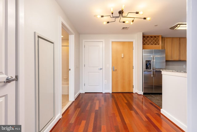 kitchen with dark wood-type flooring, a chandelier, and stainless steel refrigerator with ice dispenser