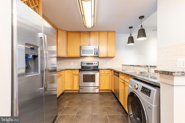 kitchen featuring stainless steel appliances, sink, pendant lighting, light brown cabinetry, and washer / clothes dryer