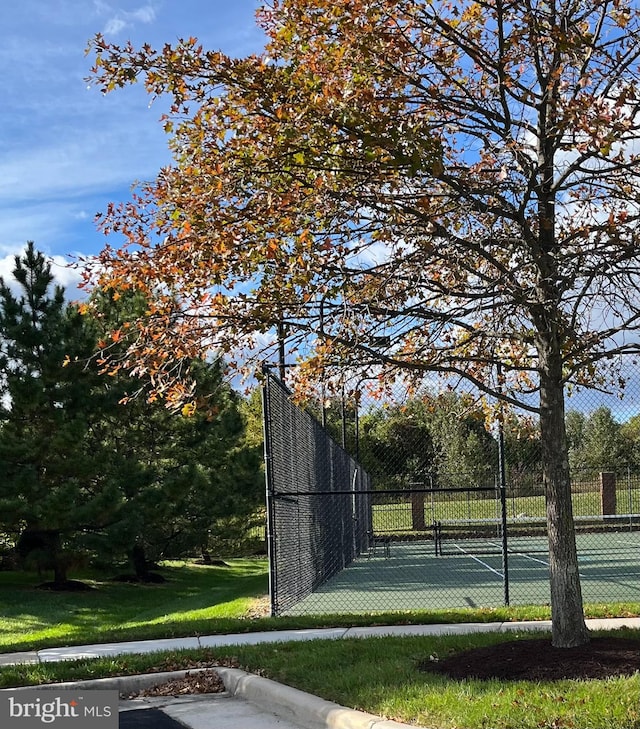 view of sport court with a yard