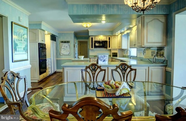 kitchen featuring kitchen peninsula, a chandelier, black appliances, crown molding, and dark hardwood / wood-style flooring