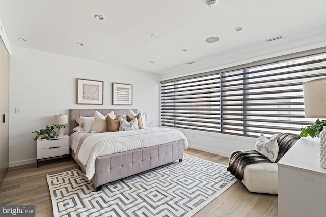 bedroom with light hardwood / wood-style flooring and multiple windows