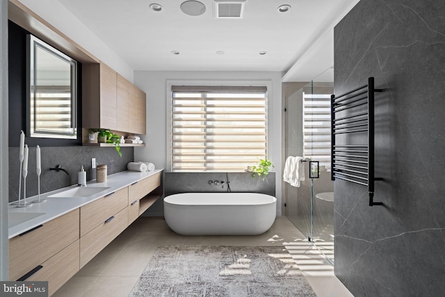 bathroom featuring vanity, radiator, separate shower and tub, and tile patterned flooring