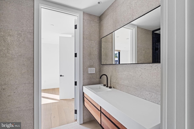 bathroom with vanity, tile walls, and hardwood / wood-style flooring