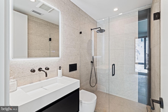 bathroom with vanity, tile walls, toilet, and walk in shower