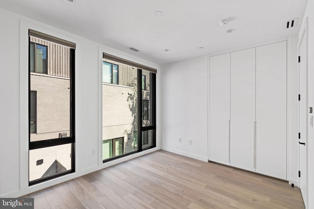 unfurnished room featuring light hardwood / wood-style floors and a wealth of natural light