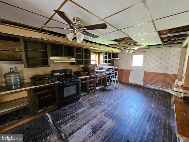 kitchen featuring black gas range oven, dark hardwood / wood-style floors, a drop ceiling, and ceiling fan