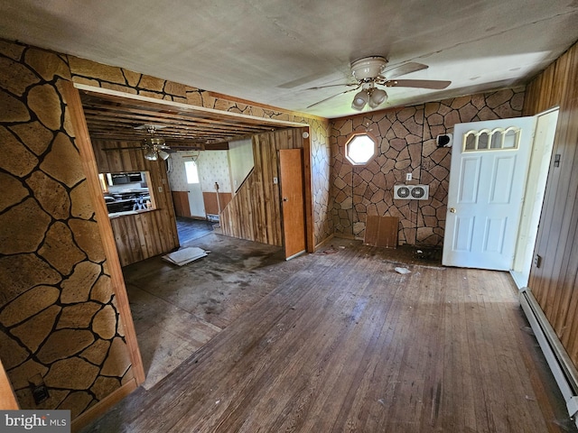 foyer with wood walls, a baseboard heating unit, dark hardwood / wood-style flooring, and ceiling fan