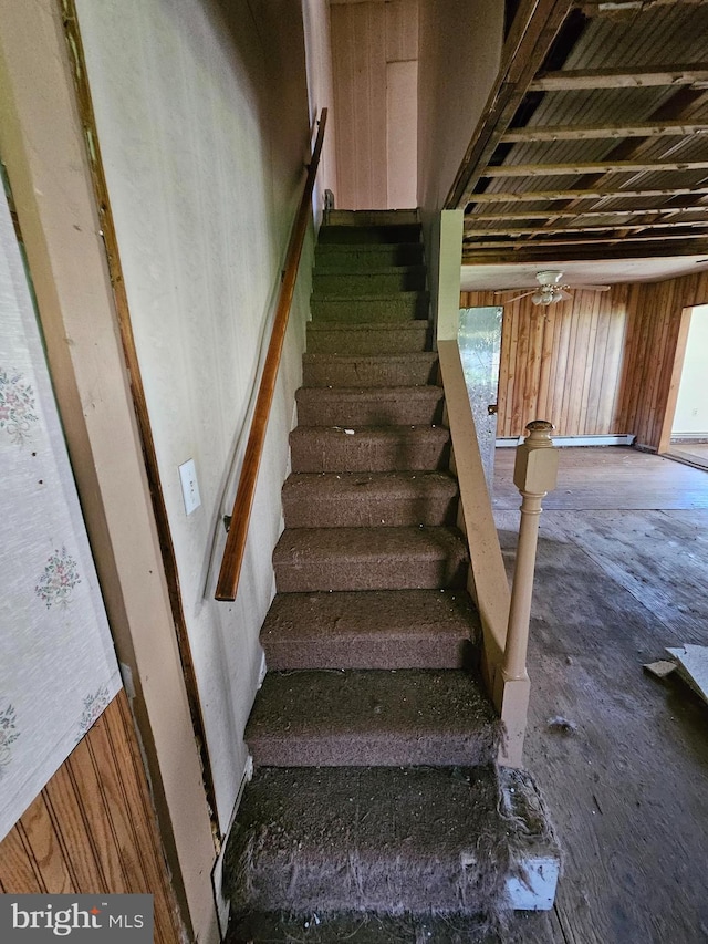 stairway featuring ceiling fan