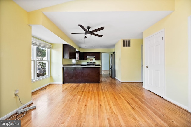 kitchen featuring sink, stainless steel fridge, light hardwood / wood-style flooring, and dark brown cabinetry