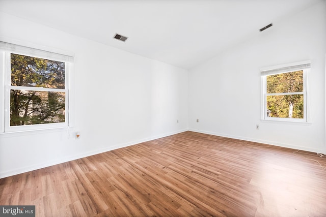 spare room with lofted ceiling and hardwood / wood-style floors